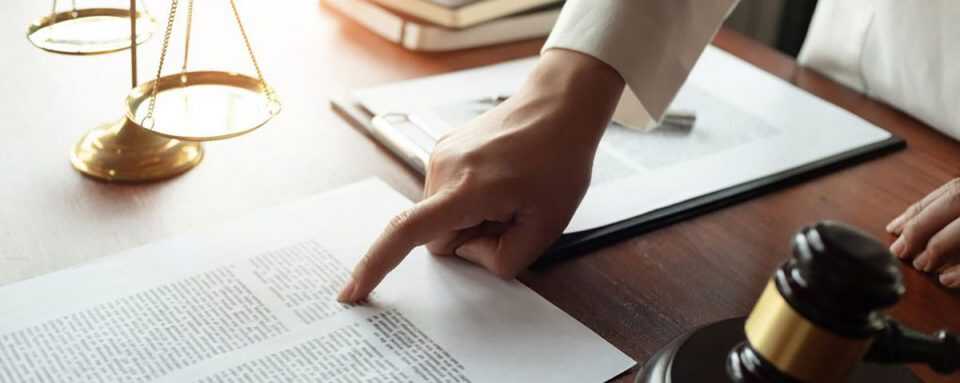 Lawyer hand pointing at paper on a desk